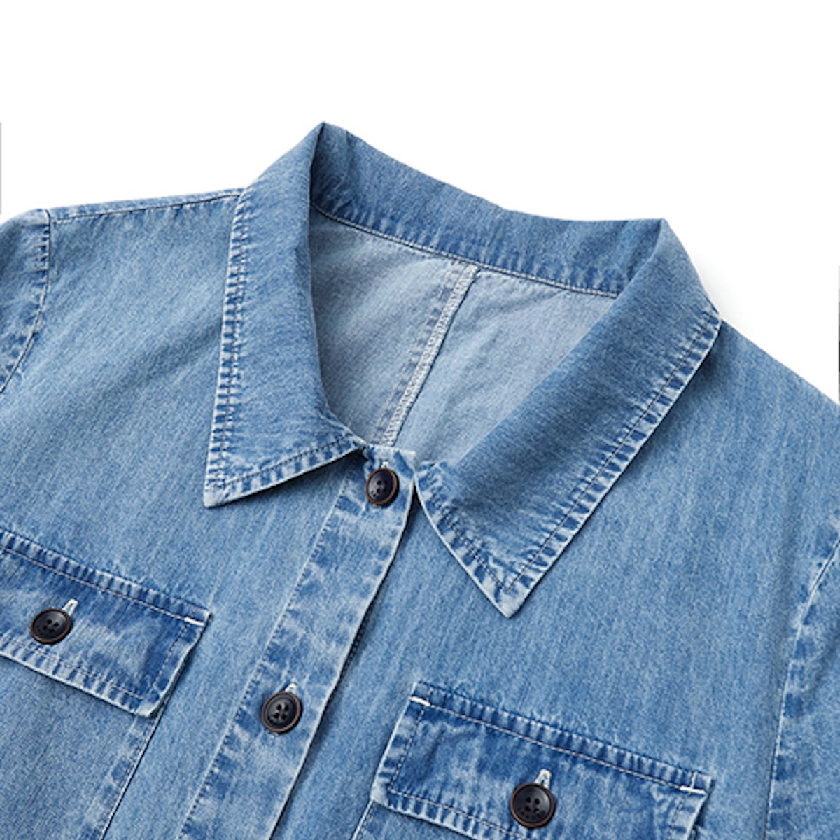 Detail of the collar, placket and flap pockets on a washed denim shirt