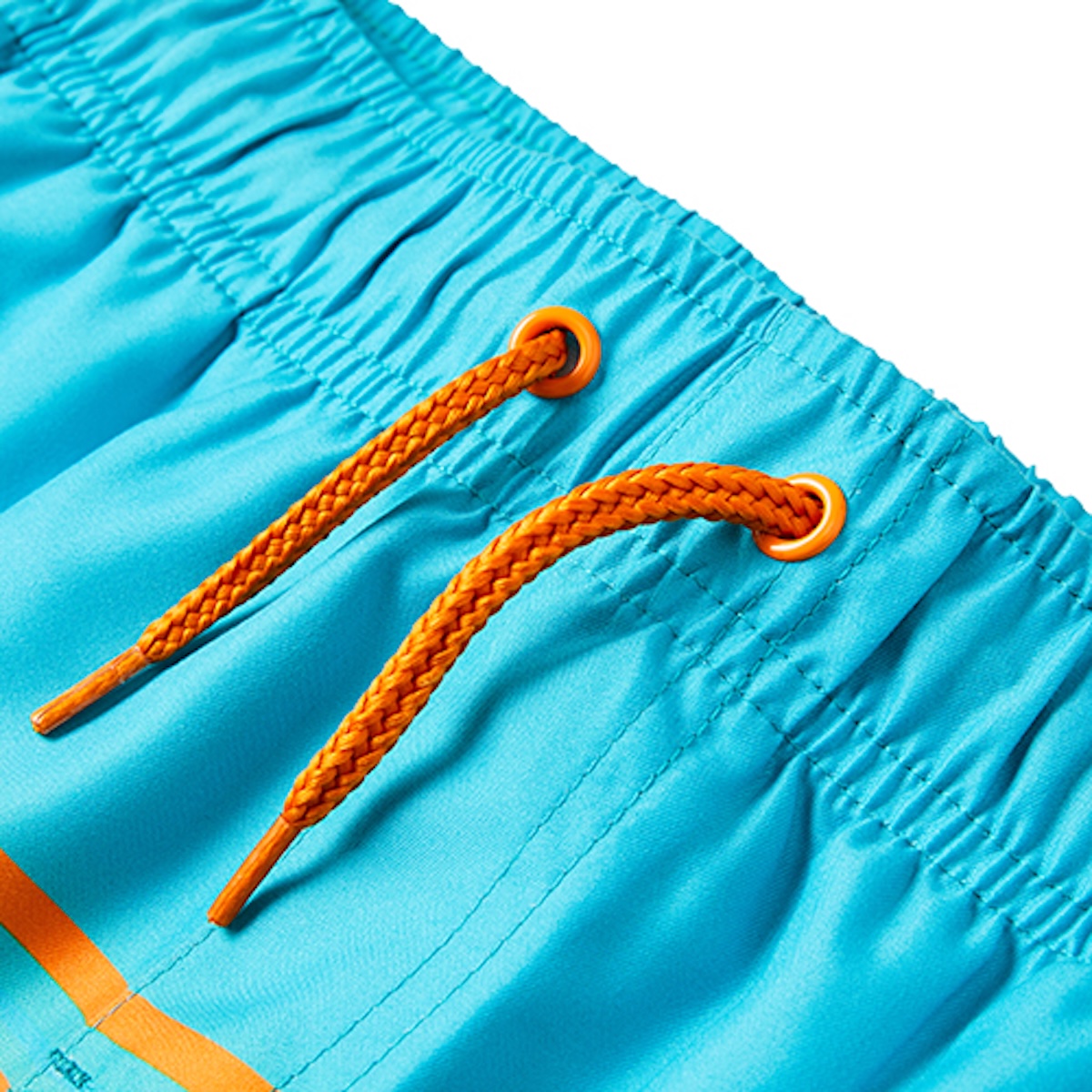 Macro detail of the orange woven drawstring and eyelets on turquoise swim shorts